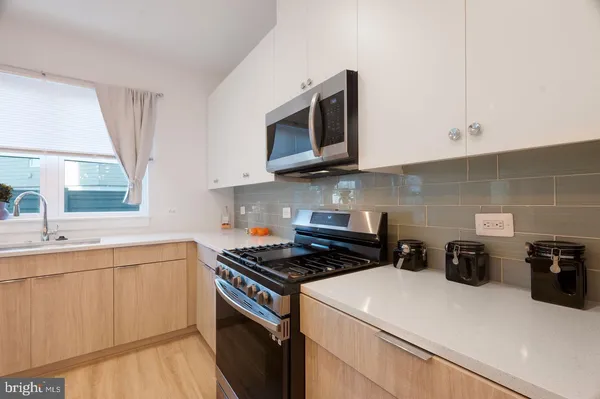 a kitchen with stainless steel appliances a sink a stove and microwave