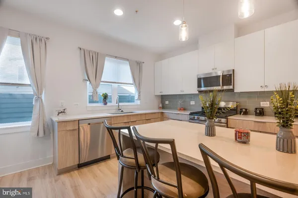 a kitchen with a table chairs microwave and cabinets