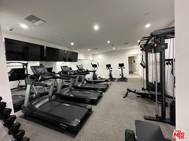 a room with gym equipment and a flat screen tv
