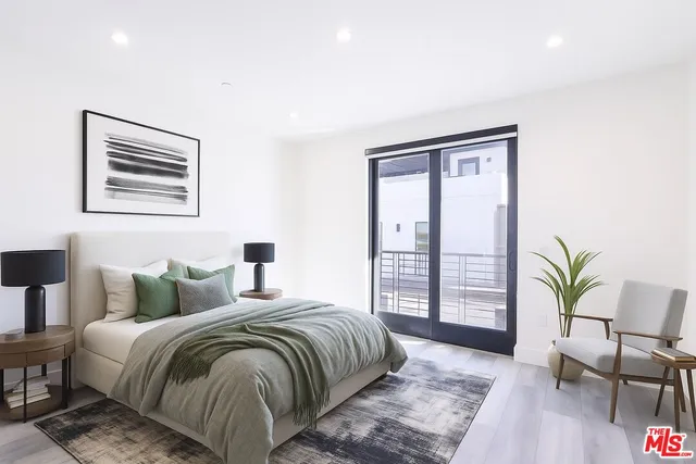 a bedroom with a large bed and a potted plant