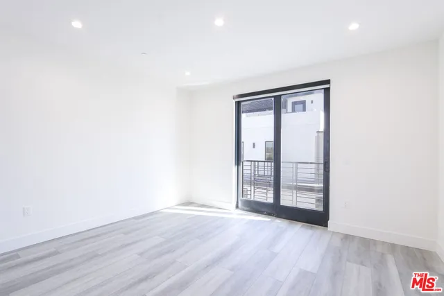 an empty room with wooden floor and sliding door