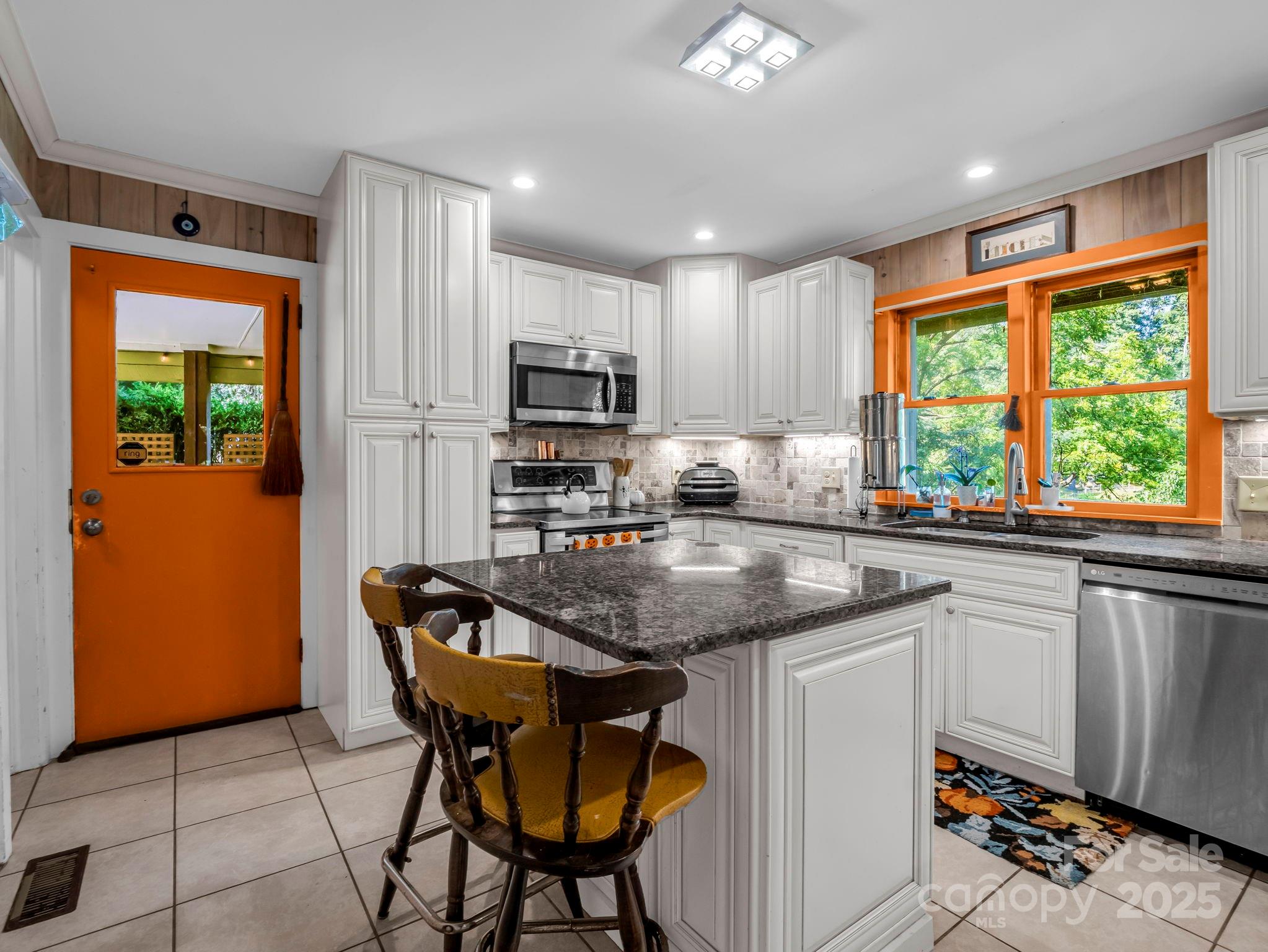 81 Jericho Drive Tryon, NC 28782 - Photo 10 of 43 a kitchen with stainless steel appliances granite countertop white cabinets a stove a sink and a microwave