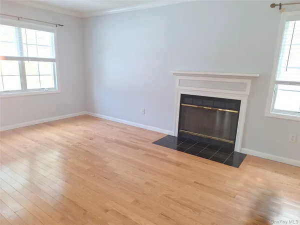 an empty room with windows and fireplace