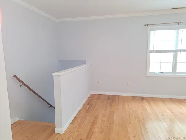 a view of a small space with wooden floor and a window
