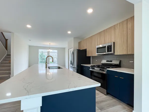 a kitchen with a sink a stove top oven and refrigerator