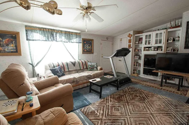a living room with furniture a flat screen tv and a floor to ceiling window