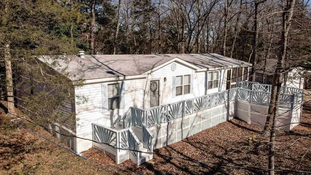 a view of a white house with a large window and lawn chairs