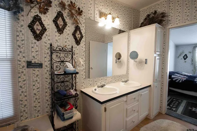 a bathroom with a sink and mirror with shower