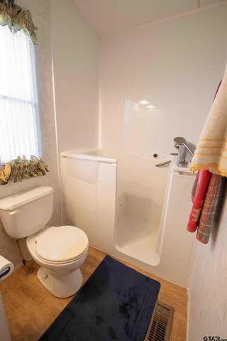 a bathroom with a toilet and a shower