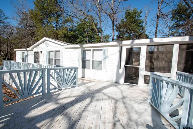 a view of a house with a wooden deck and a floor to ceiling window