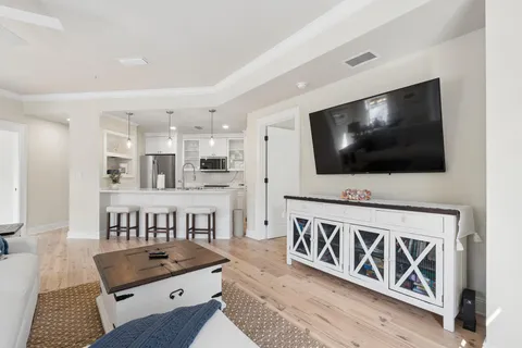 a living room with furniture a flat screen tv and a window