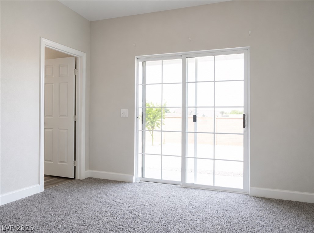 200 East Gamebird Road Pahrump, NV 89048 - Photo 12 of 23 Sliding glass doors offer access to the yard from this comfortable, carpeted room.