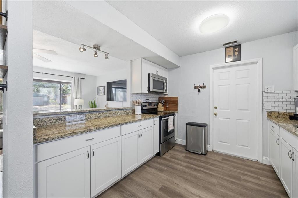 3487 Begonia Place Largo, FL 33771 - Photo 12 of 34 a kitchen with granite countertop a sink and cabinets