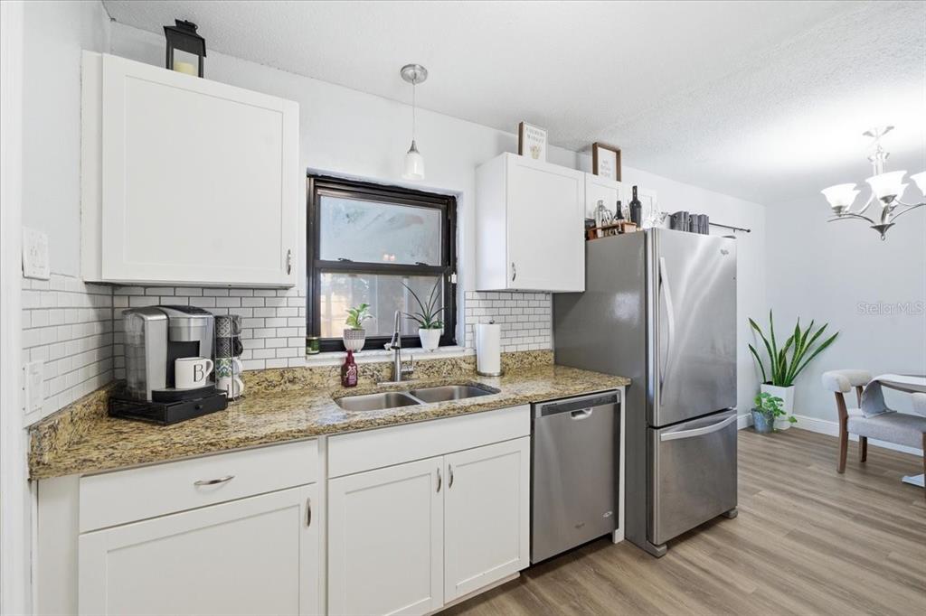 3487 Begonia Place Largo, FL 33771 - Photo 17 of 34 a kitchen with stainless steel appliances white cabinets and a refrigerator