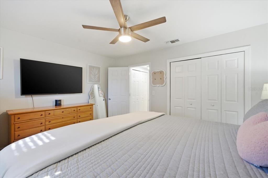 3487 Begonia Place Largo, FL 33771 - Photo 24 of 34 a bedroom with a bed and a flat screen tv on the dresser