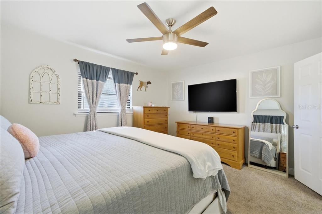 3487 Begonia Place Largo, FL 33771 - Photo 25 of 34 a bedroom with a bed and a flat screen tv