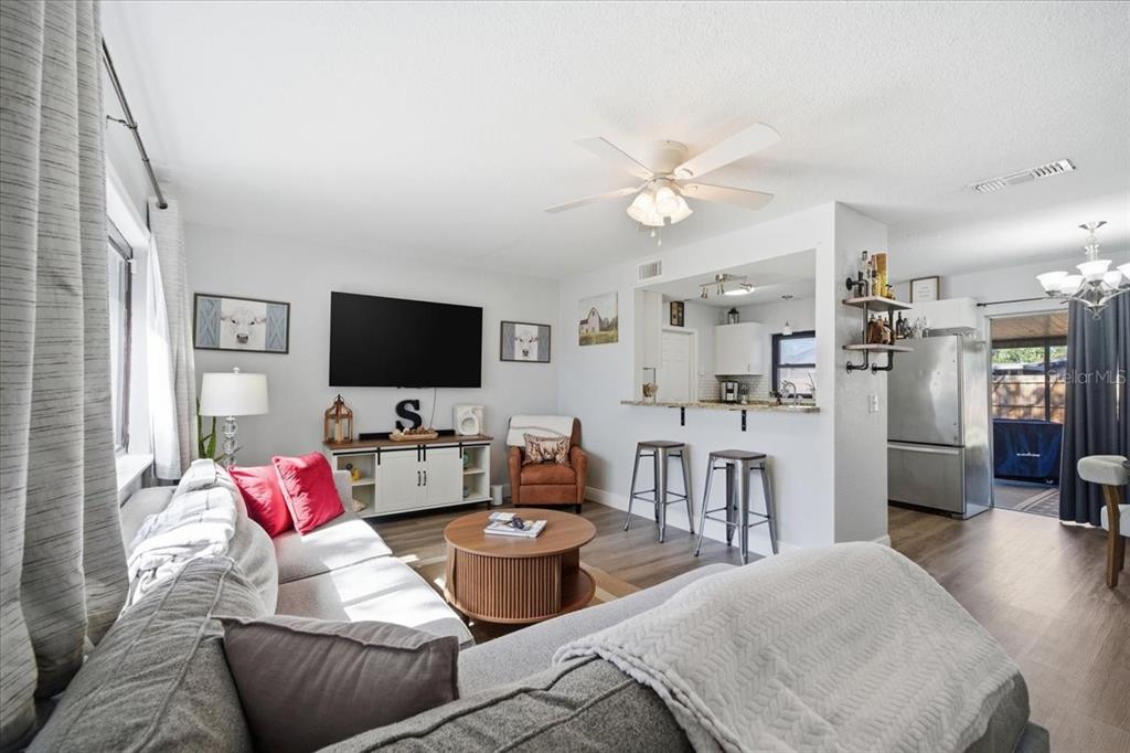 3487 Begonia Place Largo, FL 33771 - Photo 9 of 34 a living room with furniture kitchen view and a flat screen tv