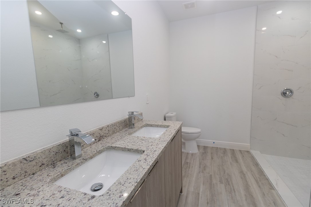 3105 Myra Lane LaBelle, FL 33935 - Photo 12 of 29 a bathroom with a granite countertop sink a toilet and a mirror