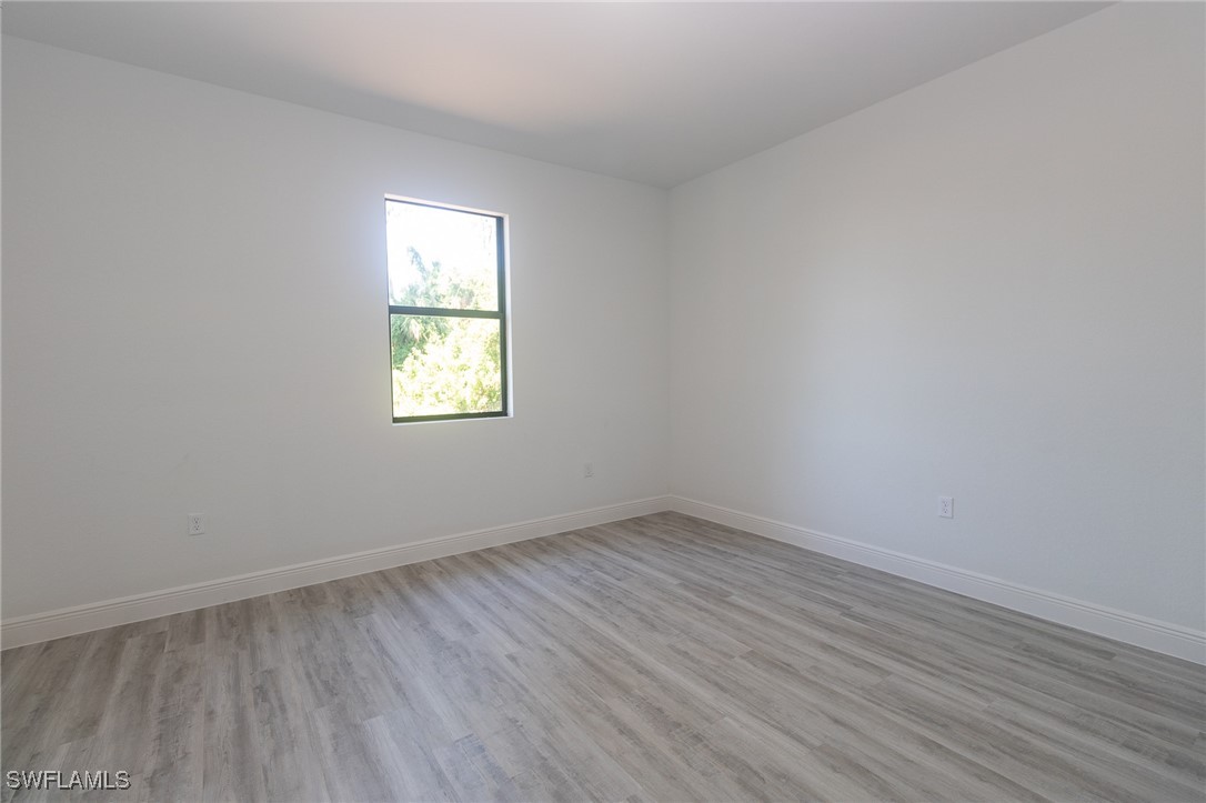 3105 Myra Lane LaBelle, FL 33935 - Photo 14 of 29 an empty room with wooden floor and windows
