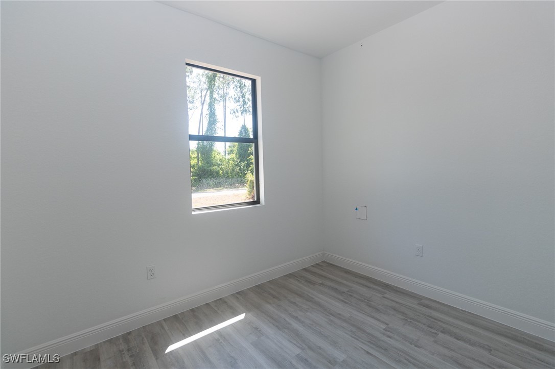 3105 Myra Lane LaBelle, FL 33935 - Photo 19 of 29 an empty room with wooden floor and windows