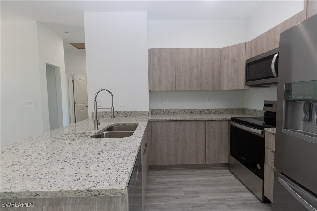 3105 Myra Lane LaBelle, FL 33935 - Photo 7 of 29 a kitchen with granite countertop a sink and a stove top oven
