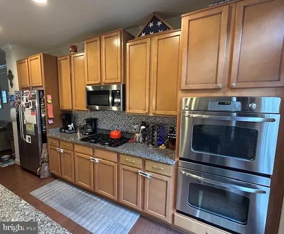 a kitchen with stainless steel appliances a stove a sink a microwave and cabinets