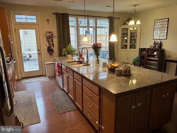 a kitchen with kitchen island granite countertop a sink dishwasher stove and cabinets