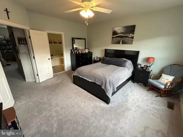 a spacious bedroom with a bed and a chandelier