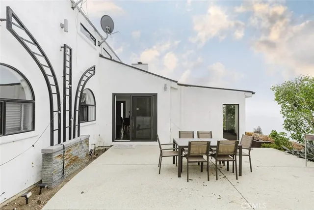 a view of a patio with table and chairs and potted plants