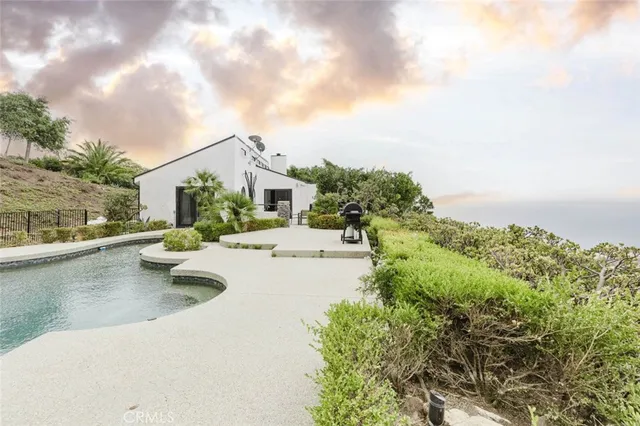 a view of swimming pool with outdoor seating and plants