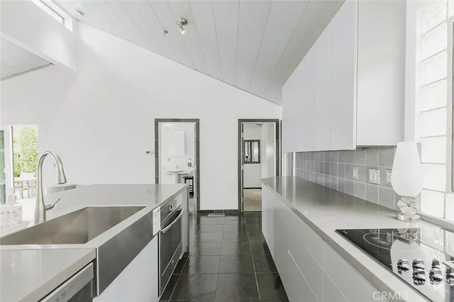 a kitchen with a sink and a stove top oven