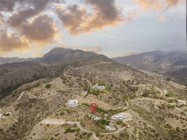 a view of a dry yard with mountains in the background