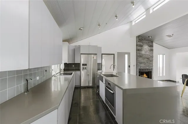 a large white kitchen with stainless steel appliances