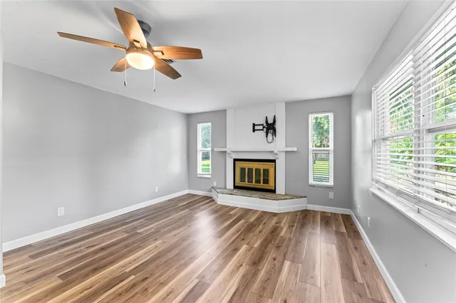 a view of a bedroom with wooden floor and windows
