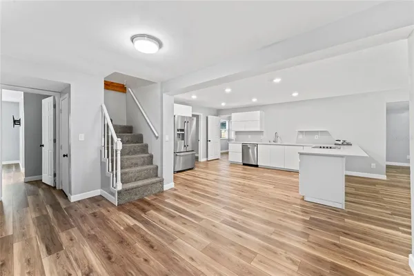 a view of a kitchen with wooden floor and electronic appliances