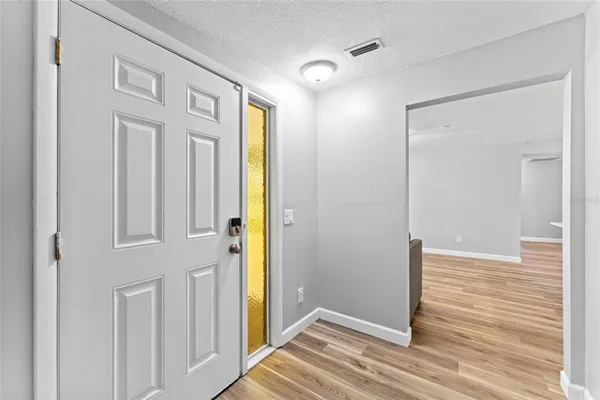a view of a hallway with wooden floor and entryway