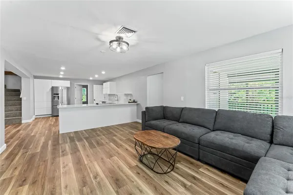 a living room with furniture and a wooden floor