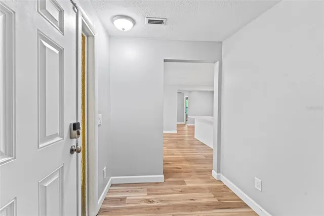 a view of a hallway with wooden floor and staircase