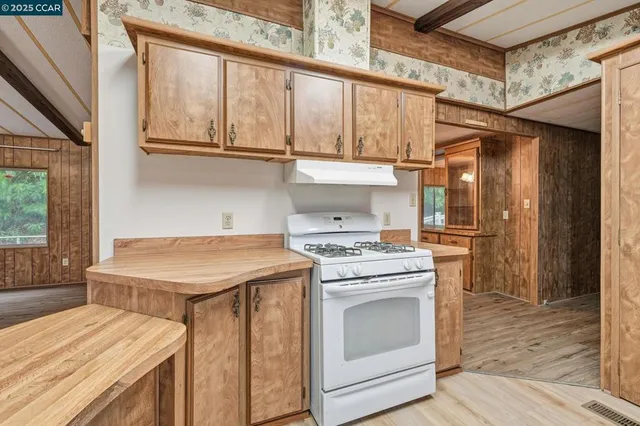 a kitchen with a stove and a wooden floor