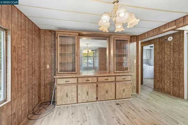 a view of a hallway with wooden floor and chandelier