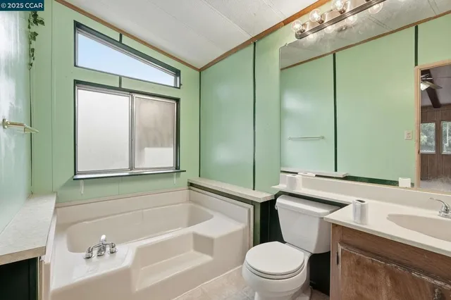 a bathroom with a sink a toilet a mirror and shower