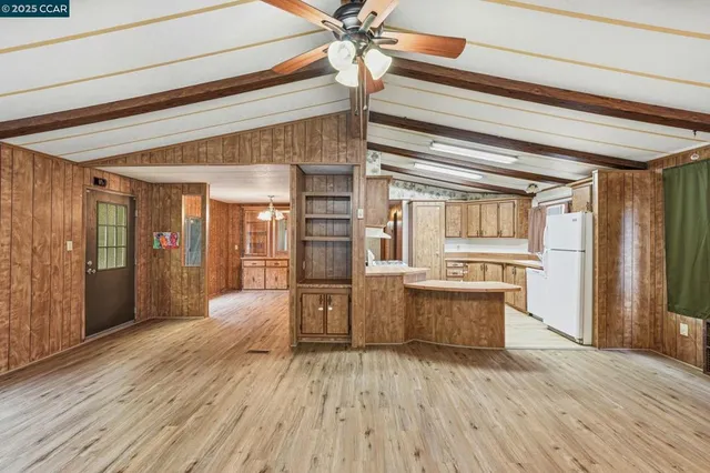 a large kitchen with cabinets wooden floor and stainless steel appliances