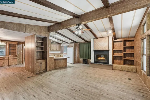 a view of an empty room with a fireplace and a window