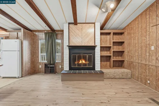 a view of an empty room with a fireplace and a window