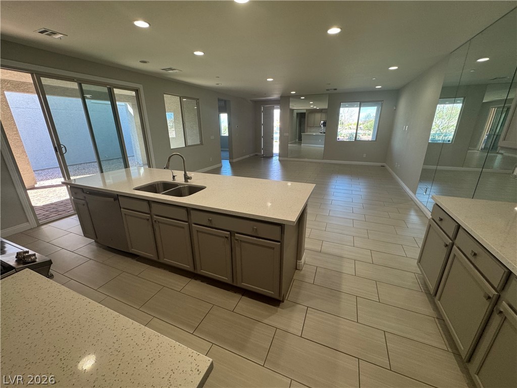 1051 East Sunset Road Henderson, NV 89011 - Photo 36 of 36 Kitchen featuring light stone countertops, an island with sink, dishwasher, recessed lighting, and open floor plan