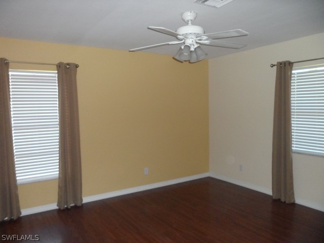 18395 Fern Road Fort Myers, FL 33967 - Photo 15 of 21 an empty room with wooden floor chandelier fan and windows