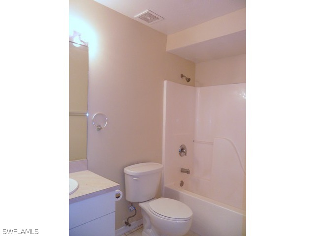 18395 Fern Road Fort Myers, FL 33967 - Photo 17 of 21 a white toilet sitting next to a bathroom sink and a shower
