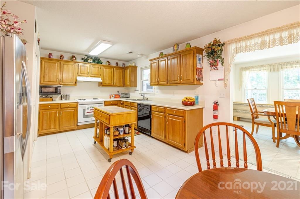 115 Banksridge Road Fort Mill, SC 29715 - Photo 16 of 29 a kitchen with stainless steel appliances granite countertop a dining table chairs sink and cabinets