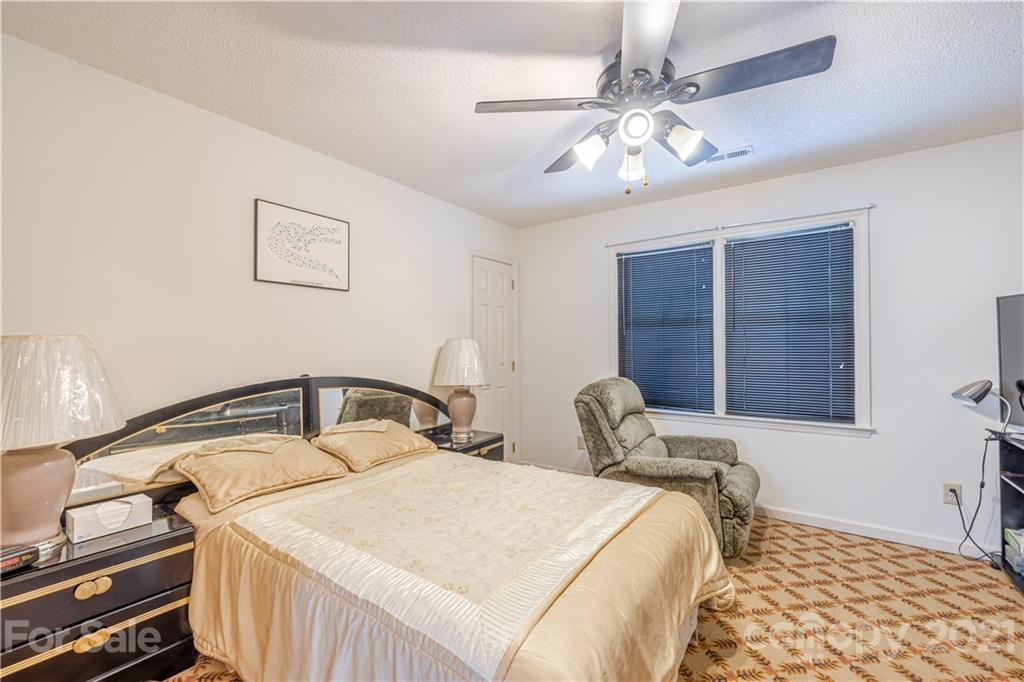 115 Banksridge Road Fort Mill, SC 29715 - Photo 27 of 29 a bedroom with a bed and a chandelier