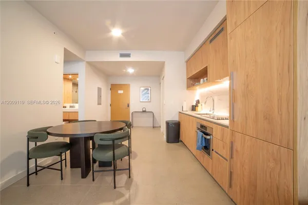 a kitchen with a table chairs sink and cabinets